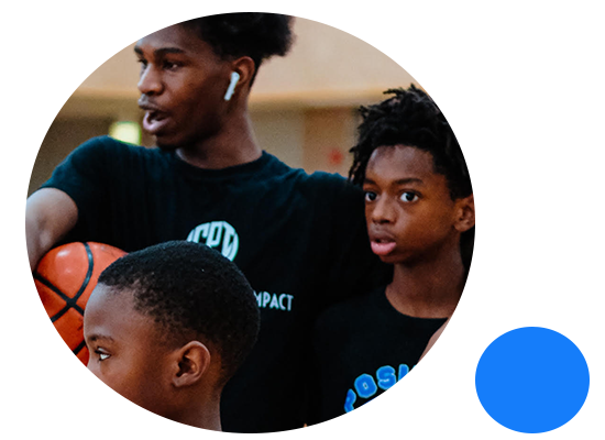 Chicago Positive Impact mentor standing with youth players in the gym
